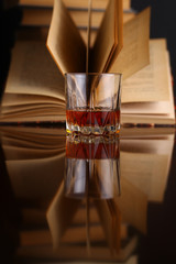 Glass of whiskey and books