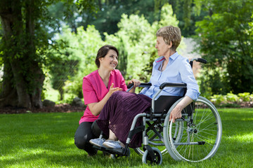 Woman on wheelchair relaxing in garden
