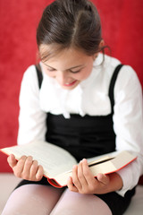 Ciekawa lektura - dziewczynka czyta książkę - obrazy, fototapety, plakaty
