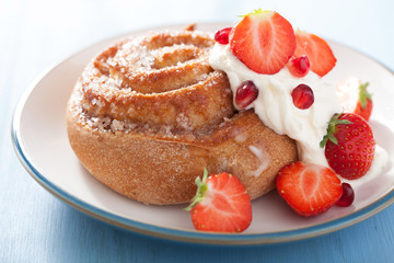 sweet cinnamon roll with cream and strawberry for breakfast