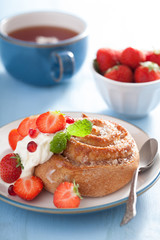 sweet cinnamon roll with cream and strawberry for breakfast