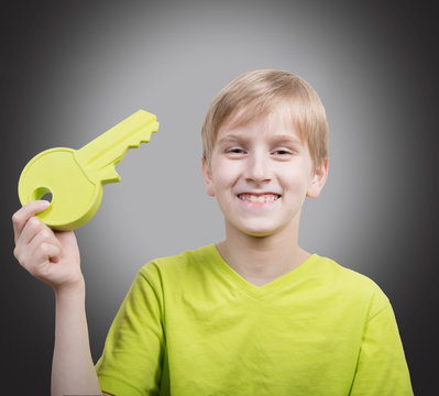 Studio portrait of a boy with a big key