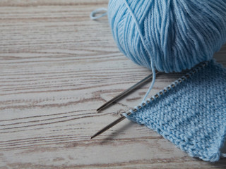 Ball of yarn and knitting on a wooden table