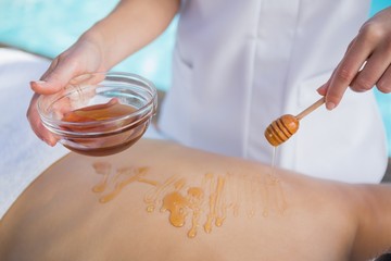 Woman getting a honey beauty treatment poolside