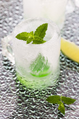 glass made of ice with vodka, lemon and mint