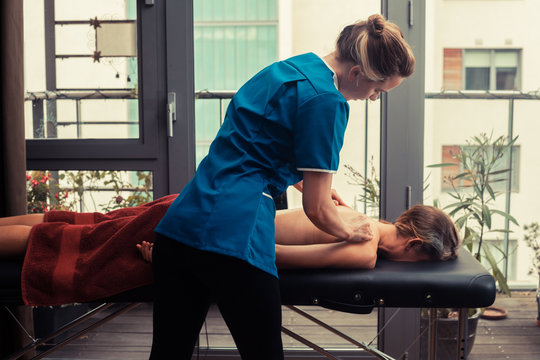 Massage therapist treating patient