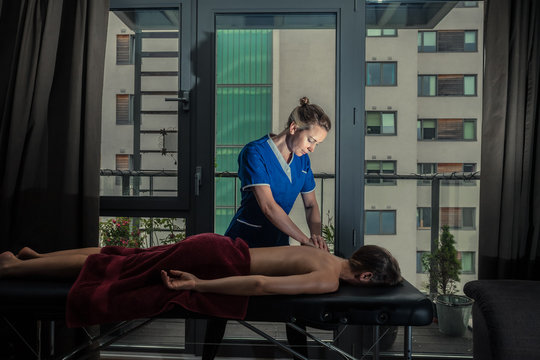 Massage therapist treating patient at home