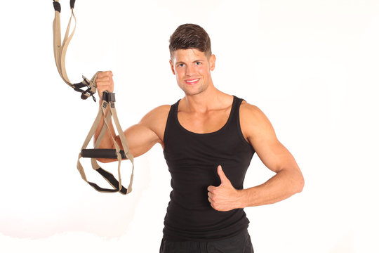 Durchtrainierter Mann mit TRX