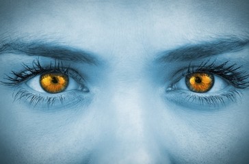 Bright orange eyes on female face