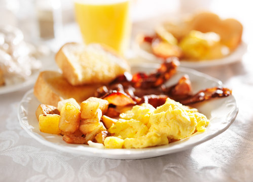 full breakfast with scrambled eggs, fried potatoes and bacon,