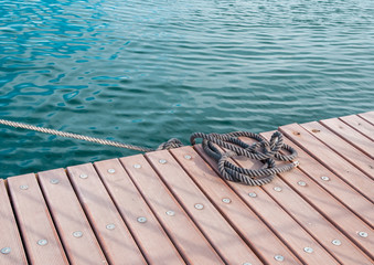 Coiled marine rope on wooden pier - 67001369