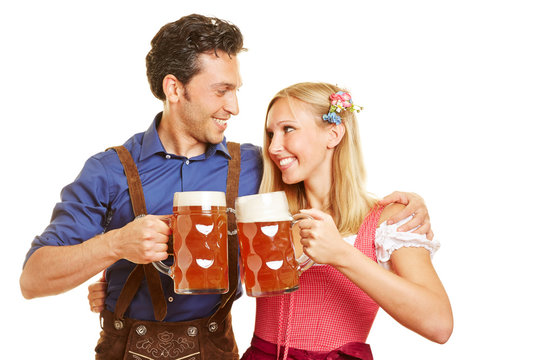 Paar trinkt Bier in Dirndl und Lederhose