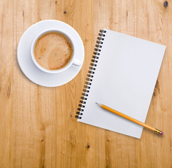 Kaffeetasse und Notizblock auf Holz