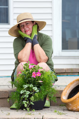 Attractive senior woman potting up plants