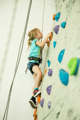 girl climbing up the wall - obrazy, fototapety, plakaty