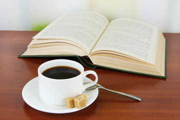 Cup of coffee with sugar and book