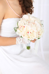 Naklejka premium Bride holding wedding bouquet of white peonies, close-up,
