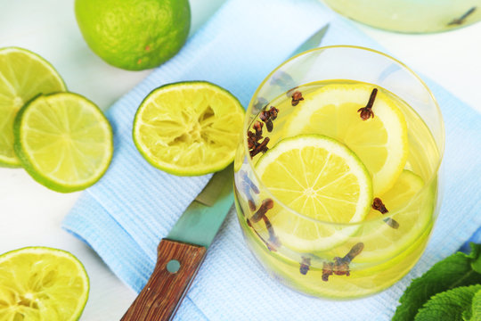 Fresh summer drink with lime and cloves in glass,