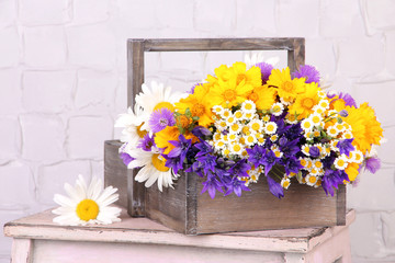 Beautiful flowers in crate on light background