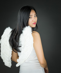 Rear view of a Upset Asian young woman dressed up as an angel