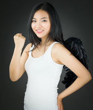Asian young woman dressed up as an angel celebrating her success