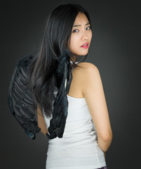 Rear view of a Upset Asian young woman dressed up as an angel