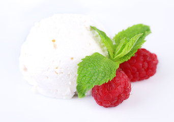 Creamy ice cream with raspberries and mint leaves isolated