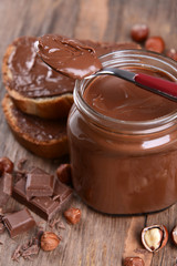 Sweet chocolate cream in jar on table close-up