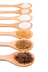 Various type of sugar on wooden spoon over white background