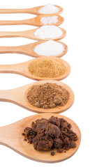 Various type of sugar on wooden spoon over white background