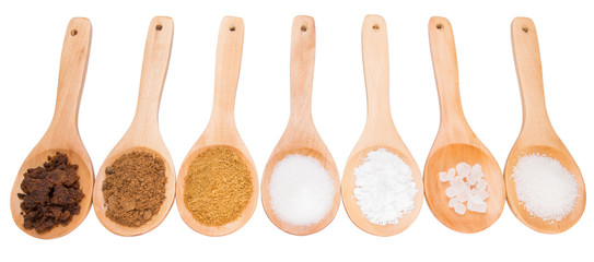 Various type of sugar on wooden spoon over white background