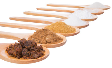 Various type of sugar on wooden spoon over white background