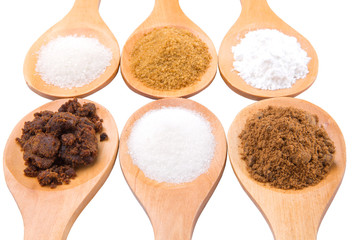 Various type of sugar on wooden spoon over white background