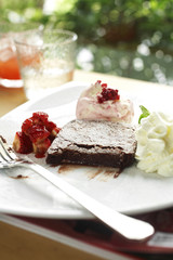 close up chocolate cake and strawberry sauce in white dish
