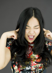 Asian young woman shouting with hands in ear