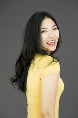 Fototapeta premium Side profile of an Asian young woman smiling