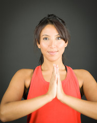 Portrait of a young woman welcoming with her hands clasped