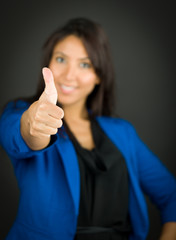 Confident young businesswoman showing thumb up sign