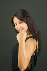 Fototapeta premium Excited young woman showing fist and celebrating success