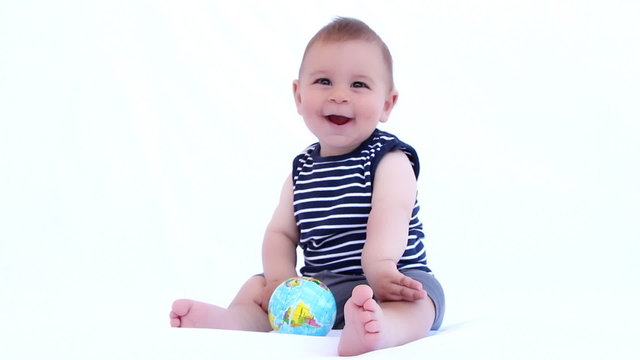 Baby boy playing with globe ball on a white background
