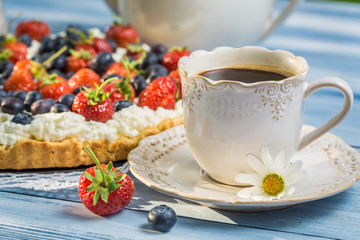 Close-up on coffee and tart with strawberries and blueberries