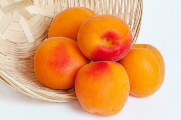 Abricots dans une corbeille sur fond blanc