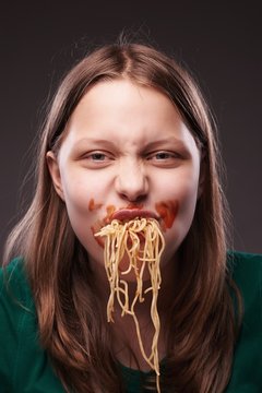 Teen girl chewing pasta