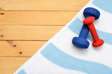 Towel and dumbbells on wood