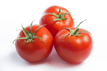 Three red tomatoes on a white background