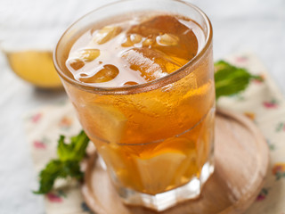 Iced tea with lemon slices, selective focus