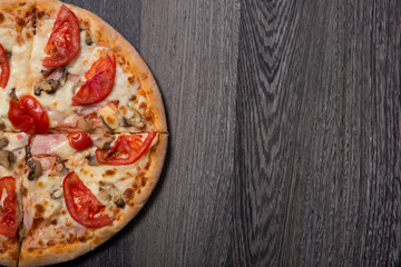 Top view of delicious Italian pizza with ham and tomatoes