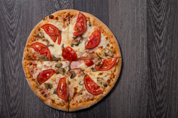 High angle view of delicious Italian pizza with ham and tomatoes