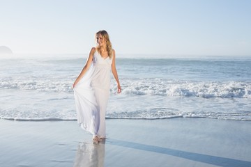 Fototapeta na wymiar Pretty blonde at the beach in white sundress