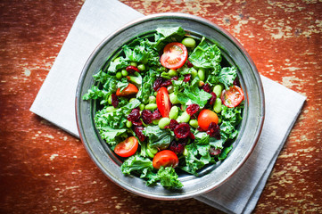Kale and edamame salad on rustic background